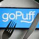 GoPuff app on phone screen on top of plate with fork and knife